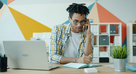 Employee juggling a phone call and laptop